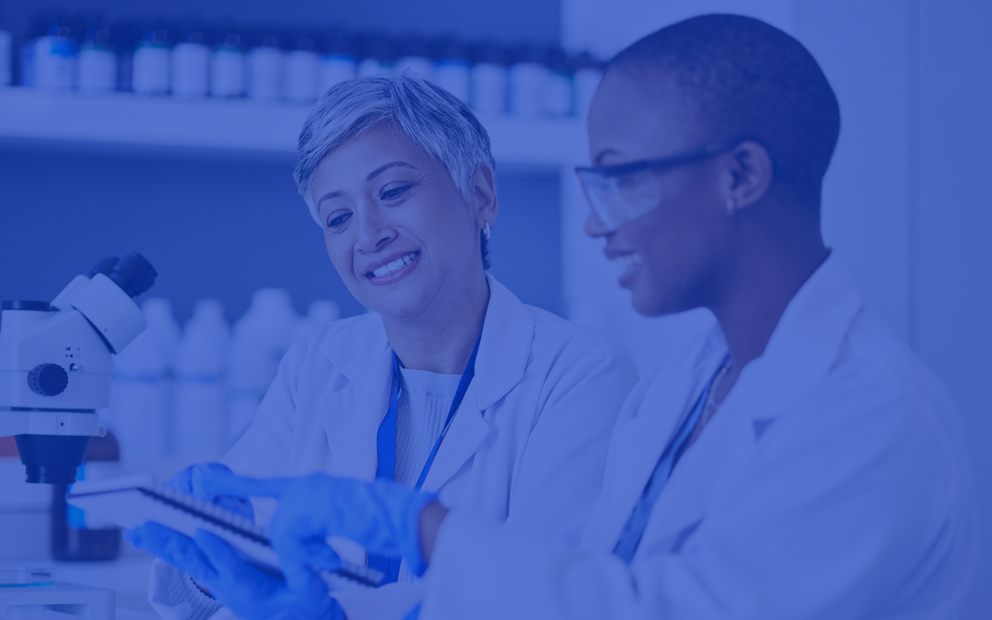 Two women in a lab looking down at a notepad