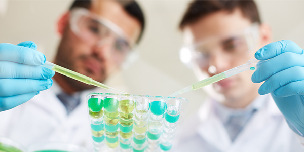 Two men in lab coats using pipettes