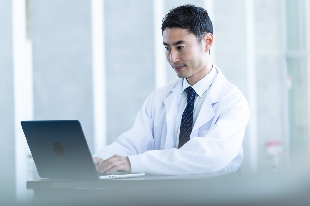 Man in a lab coat working on a computer