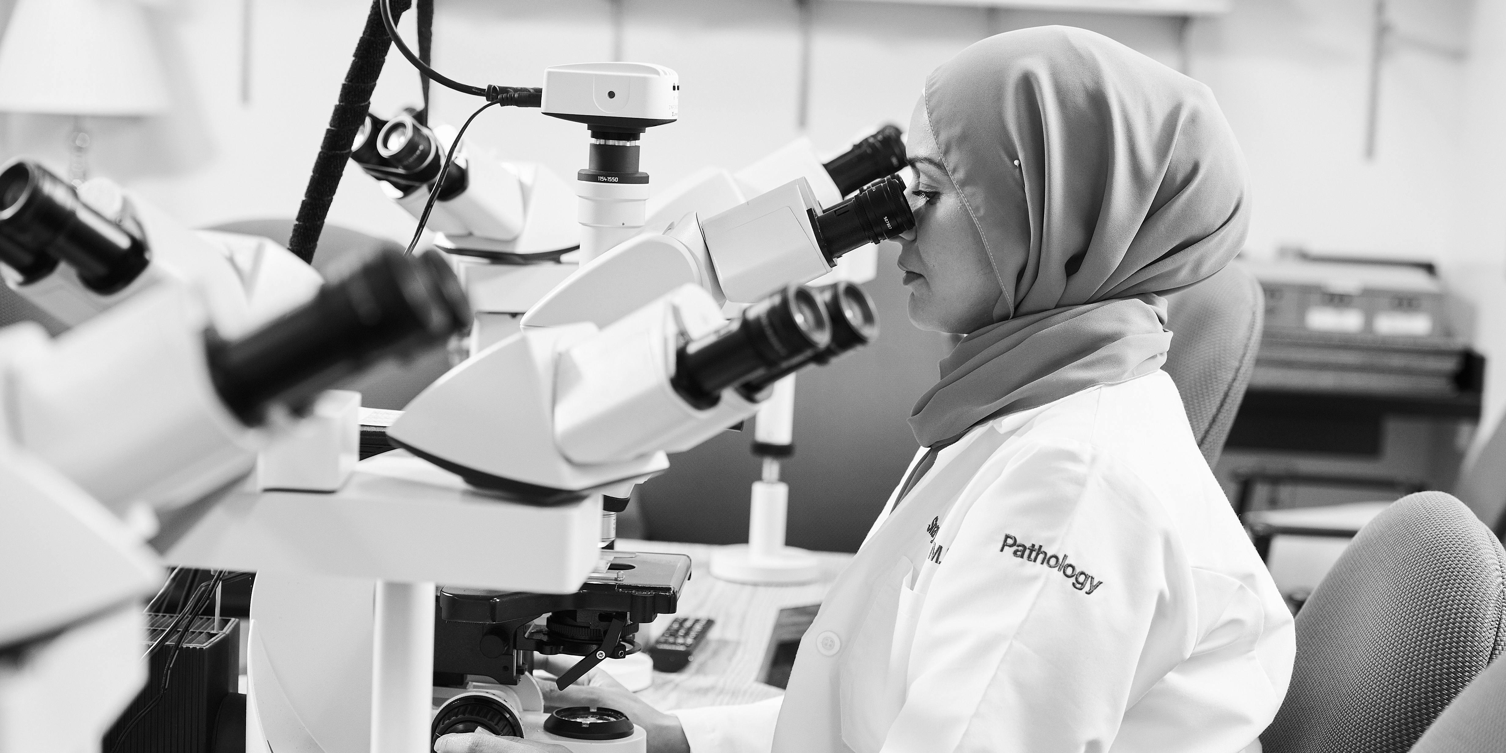 Woman in Lab looking into a microscope